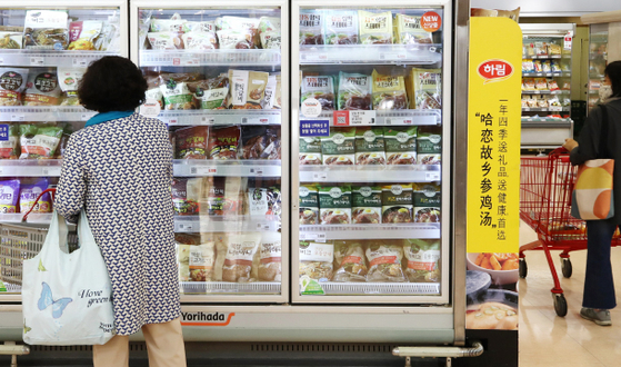 A shopper in front of the frozen food section at a store in Seoul on Tuesday. Due to the coronavirus pandemic that has forced people to eat at home, frozen food sales, including frozen dumplings as well as home meal replacements, surged in the first quarter. The sale of frozen foods is estimated to have risen around 25 percent in the first quarter, according to market research company Kantar. [YONHAP]