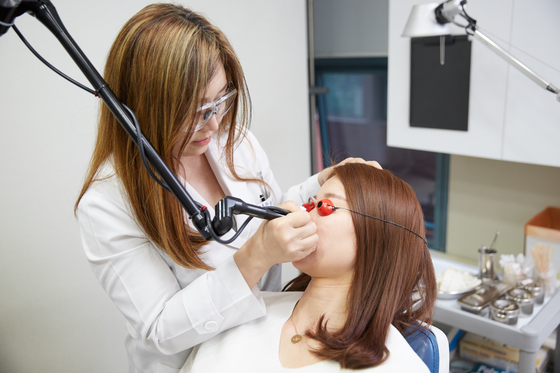 Chung Hae-shin, a cosmetic dermatologist currently working at the Massachusetts General Hospital in Boston, performs a skin care procedure on a patient. [CHUNG HAE-SHIN]