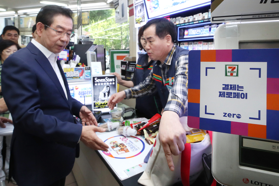 Seoul Mayor Park Won-soon, left, buys ice cream at a convenience store in Jung District, central Seoul, last September using Zero Pay. [YONHAP]