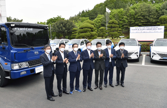 Trade Minister Sung Yun-mo, far left, and Hyundai Motor Group President Kong Young-woon, second from right, pose next to the fuel-cell truck that will be sent to the city of Changwon, South Gyeongsang, at the Korea Automotive Technology Institute in Cheonan, South Chungcheong, on Thursday. [YONHAP]