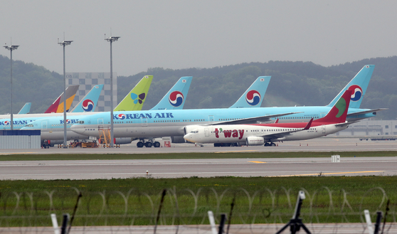 Airplanes stand idle at Incheon International Airport on Friday. Most airlines, including Korean Air Lines and Asiana Airlines, reported bad first-quarter results on Friday. [YONHAP]