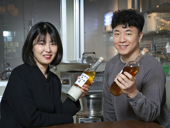 The two entrepreneurs behind Guruma Brewery, Yang Yoo-mi, left, and Lee Du-jae, show off their drink Meeting Point that they made together. [PARK SANG-MOON]