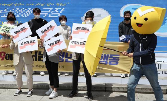 Officials from the Justice Party’s youth headquarters and youth student committee shout slogans at a press conference held in front of the Sejong Center for the Performing Arts in central Seoul on Wednesday. They are calling for the return of college tuition as classes went online amid the coronavirus outbreak, as well as a ban on layoffs and delayed wages. They are also calling for measures to deal with discrimination and hatred after the coronavirus cluster infection in Itaewon-dong, central Seoul, sparked homophobia. [YONHAP]