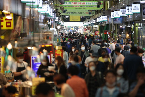 Customers crowd the Mangwon Traditional Market in western Seoul on Tuesday. Spending at such small businesses and markets has increased thanks to government emergency relief grants that were paid starting May 13. [YONHAP]