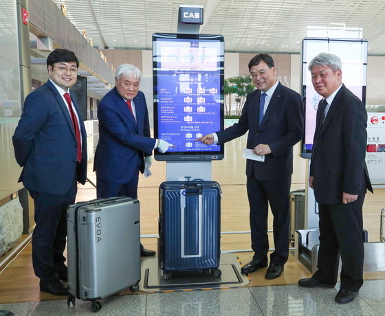 Incheon International Airport Corporation CEO Koo Bon-hwan and other delegates pose next to the country’s first smart scale installed Terminal 2 on Wednesday. The automated system not weighs luggage but it then send users updates on the progress of luggae as it is being loaded via an app. [YONHAP]