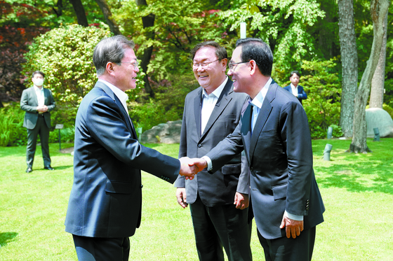 President Moon Jae-in, left, shakes hands with Rep. Joo Ho-young, floor leader of the main opposition United Future Party, right, before their luncheon meeting at the Blue House on Thursday. Rep. Kim Tae-nyeon, floor leader of the ruling Democratic Party, center, also attended the meeting. Moon invited the floor leaders on the eve of the start of the new National Assembly to seek bipartisan cooperation on state affairs amid the continuing coronavirus outbreak. The lawmakers elected last month to the 21st National Assembly will start their four-year terms on Saturday. [Blue House Press Corps]