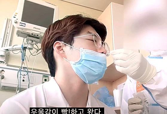 Lee Jeong-hwan, 25, undergoes a coronavirus swab test in his hospital room on May 14. [YOUTUBE SCREEN CAPTURE]