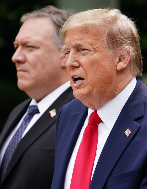 US Secretary of State Mike Pompeo, left, looks on as U.S. President Donald Trump speaks during a press conference on China in the White House Rose Garden in Washington Friday. Trump discussed tensions between the two powers over the status of Hong Kong. [AFP/YONHAP]