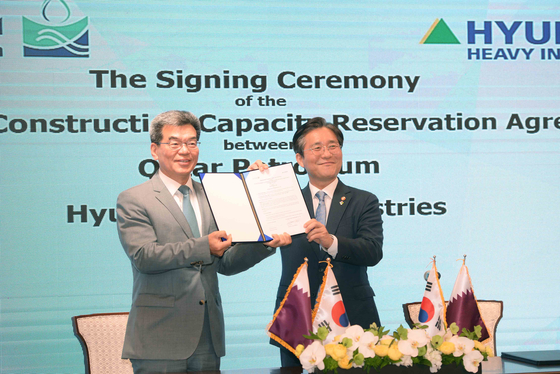 Minister of Trade, Industry and Energy Sung Yun-mo, right, and Ka Sam-hyun, CEO of Korea Shipbuilding & Offshore Engineering, pose at a ceremony at Lotte Hotel in central Seoul on Monday to sign the 23.6 trillion won ($19.26 billion) LNG vessel deal between three major shipbuilders and Qatar Petroleum. [MINISTRY OF TRADE, INDUSTRY AND ENERGY]