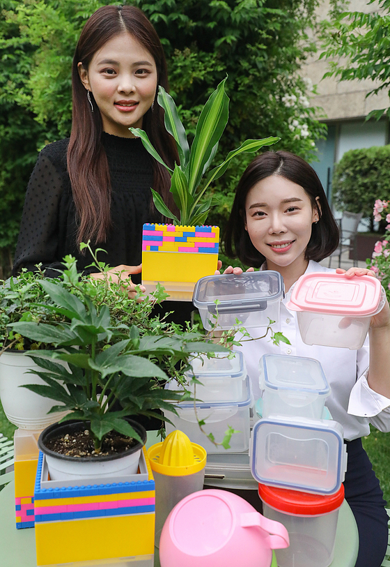 Models pose with plastic products that are being reused for different purposes at Hyundai Department Store’s Samseong-dong branch in Gangnam District, southern Seoul, on Tuesday. The department store is holding a joint campaign with the Environment Ministry to promote upcycling between June 5 and June 11 to commemorate World Environment Day. [HYUNDAI DEPARTMENT STORE]