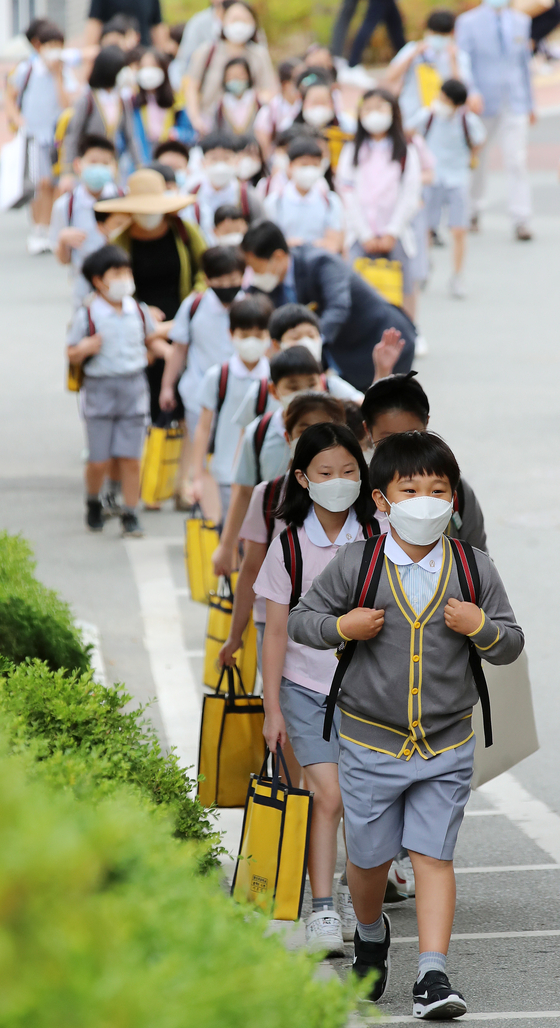 Students at Youngshin Elementary School in Daegu line up at school Wednesday as the third batch of nationwide students resumed normal classes for the first time since the pandemic struck. [NEWS1]