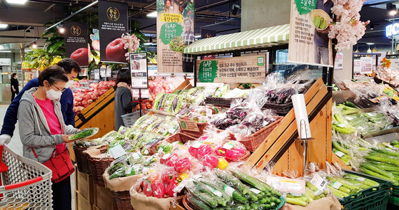 A customer examines vegetables at a Lotte Mart store [LOTTE SHOPPING]