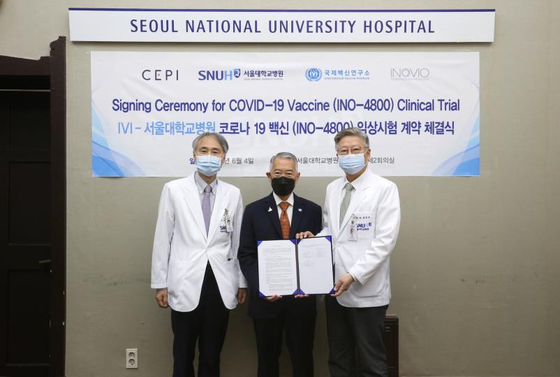 From left, Seoul National University Hospital (SNUH) Prof. Oh Myoung-don, International Vaccine Institute (IVI) Director General Jerome Kim and SNUH President Kim Yon-su pose for a photo at the signing ceremony ahead of Covid-19 vaccine clinical trials at the hospital in central Seoul, Thursday. [INTERNATIONAL VACCINE INSTITUTE, SEOUL NATIONAL UNIVERSITY HOSPITAL]
