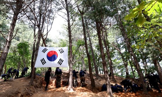 Soldiers excavate the remains of soldiers who died during the Korean War (1950-53) from a mountain in Hwacheon County, Gangwon, on Monday. [YONHAP]