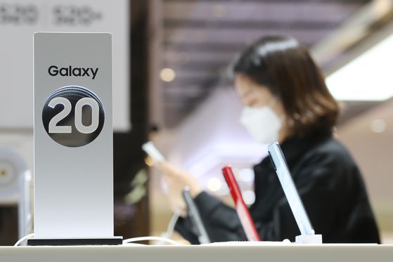 A customer checks out a smartphone at a Samsung store in Gangnam, southern Seoul, in late April. While semiconductor exports in May bounced back for the first time in three months, mobile phone exports including smartphones continued to fall due to the impact of the coronavirus pandemic. [YONHAP]