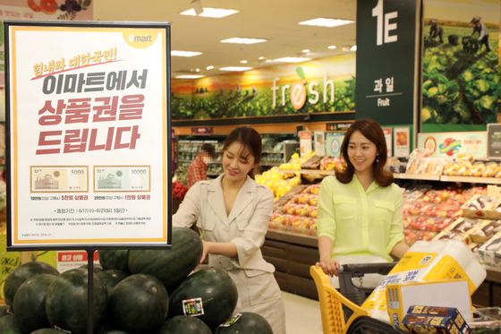Models introduce Emart’s gift certificate event at Emart's Seongsu branch in eastern Seoul on Tuesday. Emart will hold a five-day event from June 17 to June 21 to give customers up to 10,000 won ($8) in gift certificates depending on the amount of their purchases. [YONHAP]