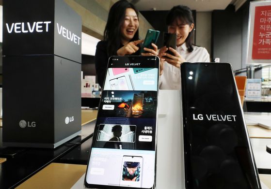 Models check out LG Electronics' new smartphone, the Velvet, on May 19 at a store in Seoul. [YONHAP]