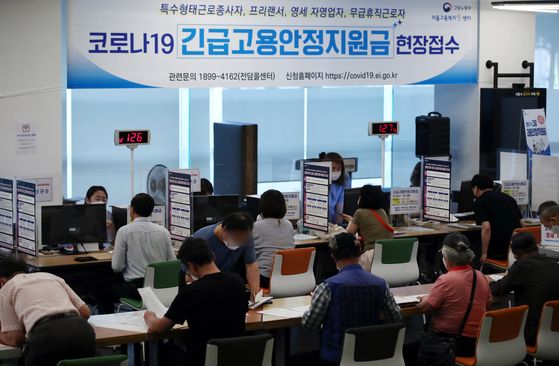Applicants apply for the government’s emergency relief fund at a welfare support center in Jung District, central Seoul, on Monday. Starting Monday, people hit hard by the coronavirus pandemic are entitled to apply for a subsidy of 1.5 million won ($1,200). Applications are open until July 3. [YONHAP]