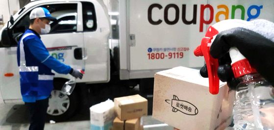 A Coupang deliveryman sterilizes boxes containing next-day delivery products on Tuesday. Coupang, an online shopping mall that suffered a mass Covid-19 infection at its logistics center in Bucheon, Gyeonggi, last month said Tuesday that it sterilizes boxes containing next-day delivery products just before delivery is complete. [YONHAP]