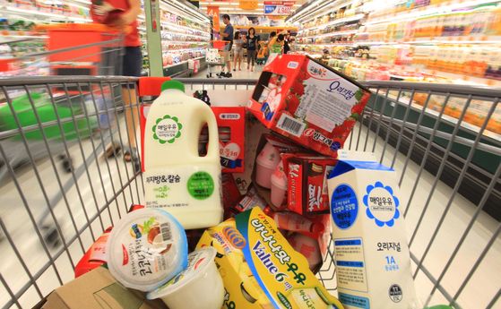 A shopping cart is filled with different types of milk and dairy products. [YONHAP]
