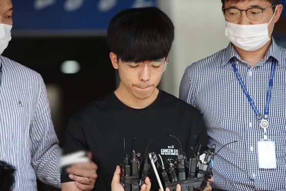 Ahn Seung-jin, 25, an accomplice of Moon Hyung-wook, the suspected operator of one of the earliest online sex trafficking rings on Telegram, is led out by police for a perp walk in front of the press at the Andong Police Precinct on Tuesday. [YONHAP]