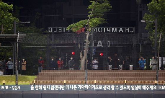 Kia Tigers fans watch a game through the outfield fence at Gwangju-Kia Champions Field in Gwangju on May 19. [YONHAP] 