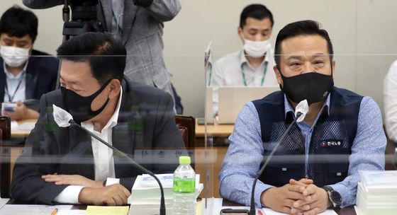 Left, Ryu Ki-jung, business representative and director at the Korea Enterprise Federation, and Lee Dong-ho, head of the Federation of Korean Trade Unions, sit next to each other at the government complex in Seoul Tuesday. While the two sides along with the government have entered the fifth meeting to set next year’s minimum wage, they have failed to achieve a consensus. [YONHAP]