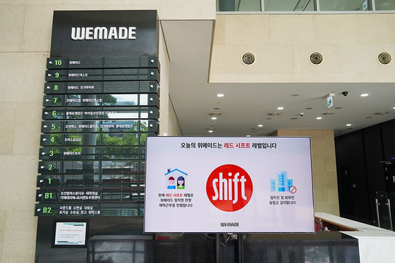 A panel at WeMade's headquarters in Pangyo, Gyeonggi, shows the Shift level. Red means the danger of infection is high and therefore all employees should stay home. [WEMADE]