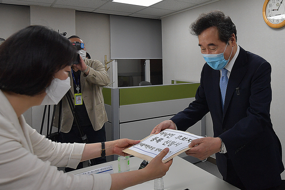 Rep. Lee Nak-yon of the Democratic Party submits his candidate application for the party's chairmanship election to a party official on Monday.  [YONHAP] 