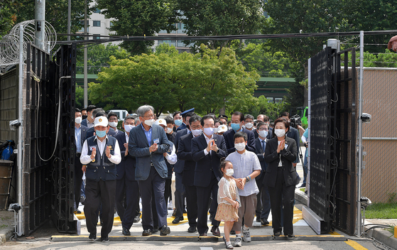 Prime Minister Chung Sye-kyun, center, and dozens of people walk into a compound in Yongsan Garrison, which will be redeveloped into an urban park in central Seoul to attend a ceremony opening the plot to the public on Tuesday.  [YONHAP]