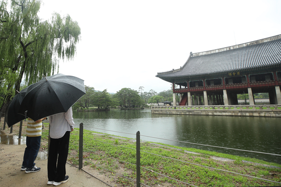 Visitors at Gyeongbok Palace in central Seoul observe the Gyeonghoeru Pavilion on July 22, 2020, which was opened to the public until Oct. 31. The pavilion, normally off-limits to the public, is considered the largest pavilion structure built during the Joseon Dynasty (1392-1910) and was used for royal banquets and special government functions, such as state occasions to welcome foreign envoys. [YONHAP]