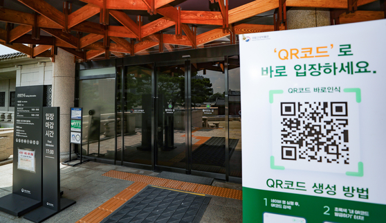 This file photo from July 21 shows signage displayed in front of the National Palace Museum of Korea directing visitors to log their arrivals through a digital QR code system as part of the museum's measures to prevent the spread of Covid-19. [YONHAP]