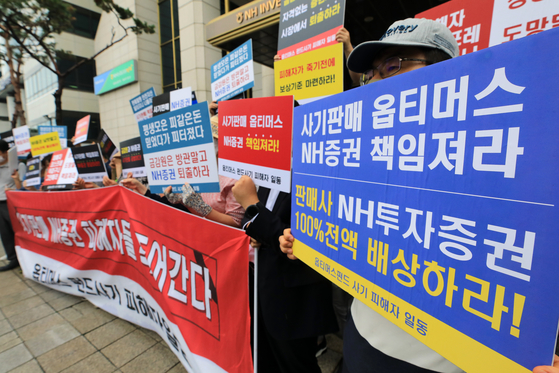 Investors stage a protest in front of the NH Investment & Securities building in the financial district of Yeouido, western Seoul, Thursday. [NEWS1]