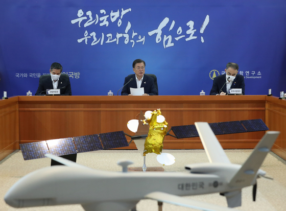 President Moon Jae-in, center, delivers an address to the Agency for Defense Development during a rare visit to the institute on Thursday. In the foreground is a model of Korea's first domestically produced mid-altitude aerial surveillance drone, currently under development by the agency. [YONHAP]