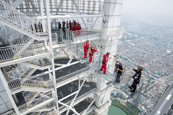 People taking a walk on the Sky Bridge at Lotte World Tower, which is set to open to the public on Friday. [LOTTE WORLD]