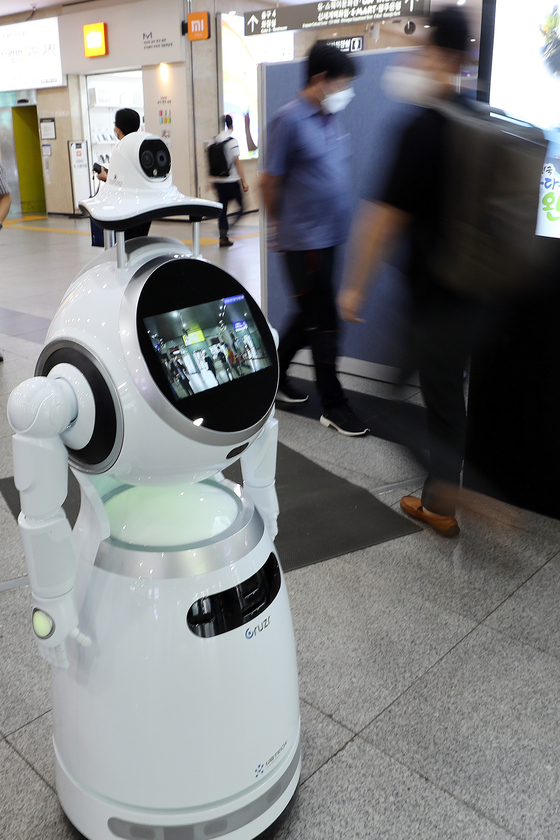 A robot equipped with a facial recognition camera and temperature scanner patrols Gwangju Bus Terminal. The robot can not only check if people have a fever, but can also tell if they’re wearing a mask or not. [YONHAP]