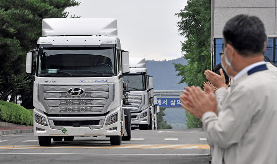 Workers at Hyundai Motor's Jeonju plant in North Jeolla celebrate as the world's first mass-produced hydrogen-powered commercial vehicles, Xcient Fuel Cells, leave to be shipped to Switzerland. [HYUNDAI MOTOR]