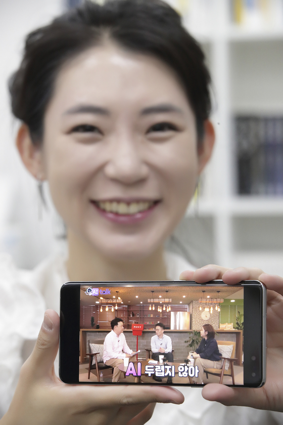 A model holds a smartphone showing content offered as part of "AI Study Week." The AI One Team, which is a collaborative endeavor between educational institutions and corporations, is holding the two-week "AI Study Week" until Aug. 21 to provide online educational content aimed at raising awareness. [YONHAP]