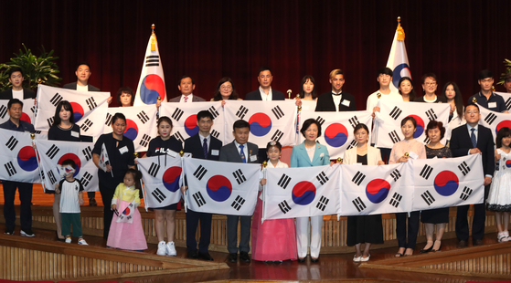 Justice Minister Choo Mi-ae, center, poses for a group photo with descendants of independence fighters who acquired Korean citizenship at the Central Government Complex in Gwacheon, Gyeonggi, on Wednesday. The Justice Ministry conferred Korean citizenship on 21 descendants of independence fighters during the Japanese colonial period to mark the 75th Liberation Day, which falls on Aug. 15.   [YONHAP]