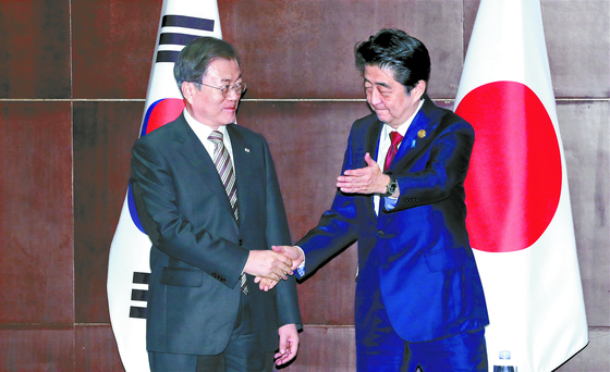  President Moon Jae-in and Japanese Prime Minister Shinzo Abe shake hands before a summit in Chengdu, China, on the sidelines of the 7th tripartite meeting among the three leaders on Dec. 24, 2019.