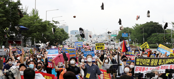 Three civic groups in protest of the government's real estate measures throw their shoes up in the air at a demonstration held in Yeongdeungpo District, western Seoul, on Aug. 1. [NEWS1]