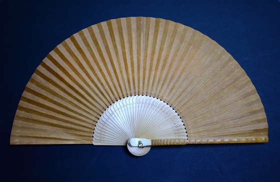 Hwangchil, or golden lacquer, is painted on a fan made with hanji, or traditional Korean paper.  [SOLUNA LIVING]