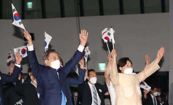 In a ceremony on Aug. 15 to mark the 75th year of Korea’s liberation from Japanese colonial rule, President Moon Jae-in and his wife raise flags. He emphasized the importance of establishing a permanent peace system with North Korea. [JOINT PRESS CORPS]