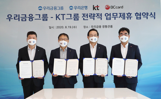 From left: Woori Bank CEO Kwon Kwang-seok, KT CEO Ku Hyeon-mo, Woori Financial Group Chairman Sohn Tae-seung and BC Card CEO Lee Dong-myun pose at an MOU signing ceremony on Aug. 19. [WOORI BANK]