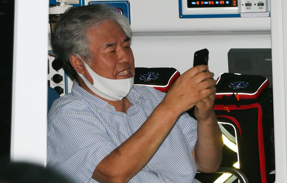 Rev. Jun Kwang-hoon, a pastor at the Sarang Jeil Church, is spotted texting inside an ambulance from the Seongbuk District Health Office in central Seoul on Monday. Jun tested positive for Covid-19 that day and was sent to an isolation ward. [NEWS1]