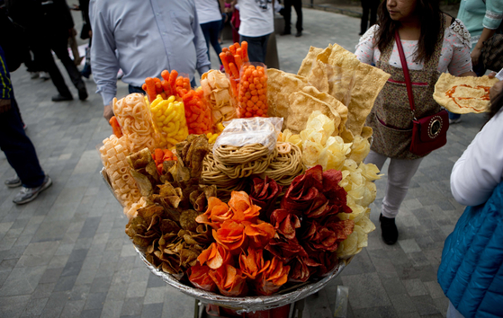 In this July 5, 2016 file photo, a street vendor sells fried snack food in Mexico City. [AP/YONHAP]