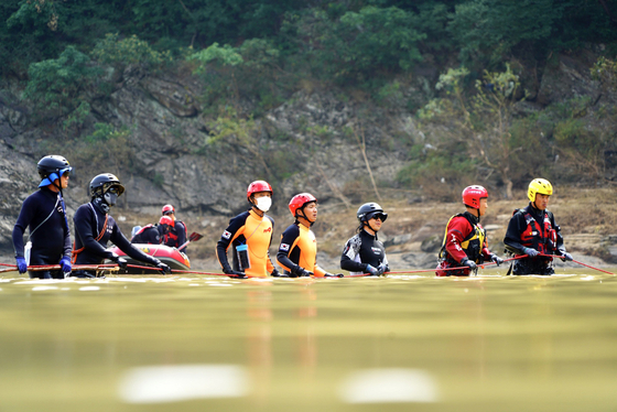 A joint search team of firefighters, police and soldiers comb through the Bukhan River in Chuncheon, Gangwon, on Thursday in search of two missing people. Three boats were overturned amid rapidly flowing floodwaters near the Euiam Dam on Aug. 6. Seven people aboard the three vessels went missing. One was rescued alive and four were found dead. [YONHAP]