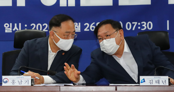 From left, Finance Minister Hong Nam-ki and Democratic Party floor leader Kim Tae-nyeon discuss next year's budget at the National Assembly in Seoul on Wednesday. [YONHAP]