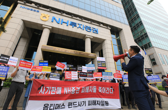 Investors in Optimus funds demand NH Investment & Securities compensate them for damages incurred in front of the brokerage firm in Yeouido, western Seoul, on July 23. The brokerage firm failed to come up with a compensation plan that day. [NEWS1]