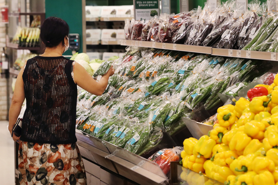 A shopper in the vegetable section of a discount mart in Seoul on Aug. 27. The longest streak of rainfall in August drove up vegetable prices. [YONHAP]